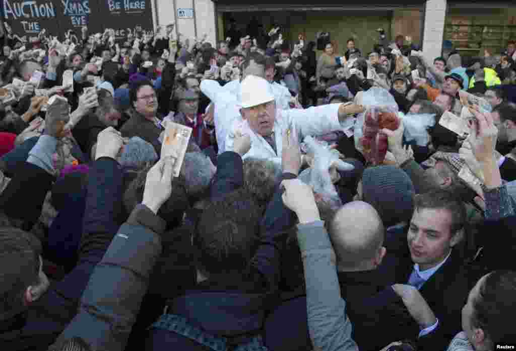 Butchers sell their remaining meat of the year at discount prices during the Christmas Eve auction at Smithfield Market in central London. &nbsp;