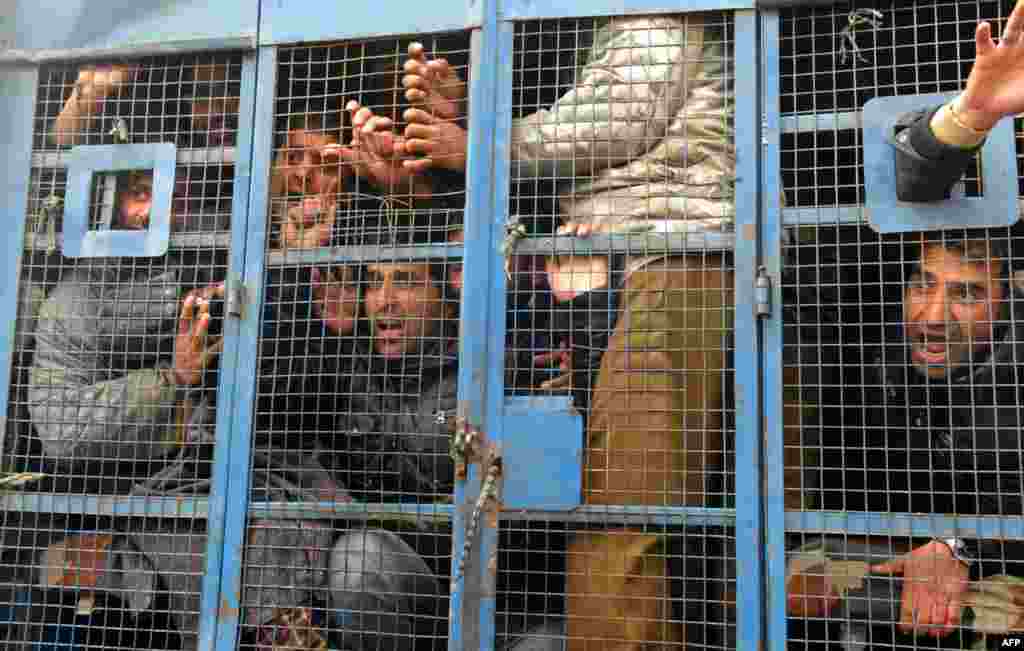 Những công chức bang Kashmir bị bắt hô to khẩu hiệu chống chính phủ khi bị nhốt trong một xe tải của cảnh sát tại Srinagar. Cảnh sát Ấn Độ bắt giữ hàng chục công chức khi những người này cố gắng tổ chức một cuộc biểu tình tuần hành đòi qui định rõ những việc làm hợp đồng và đòi tăng lương.