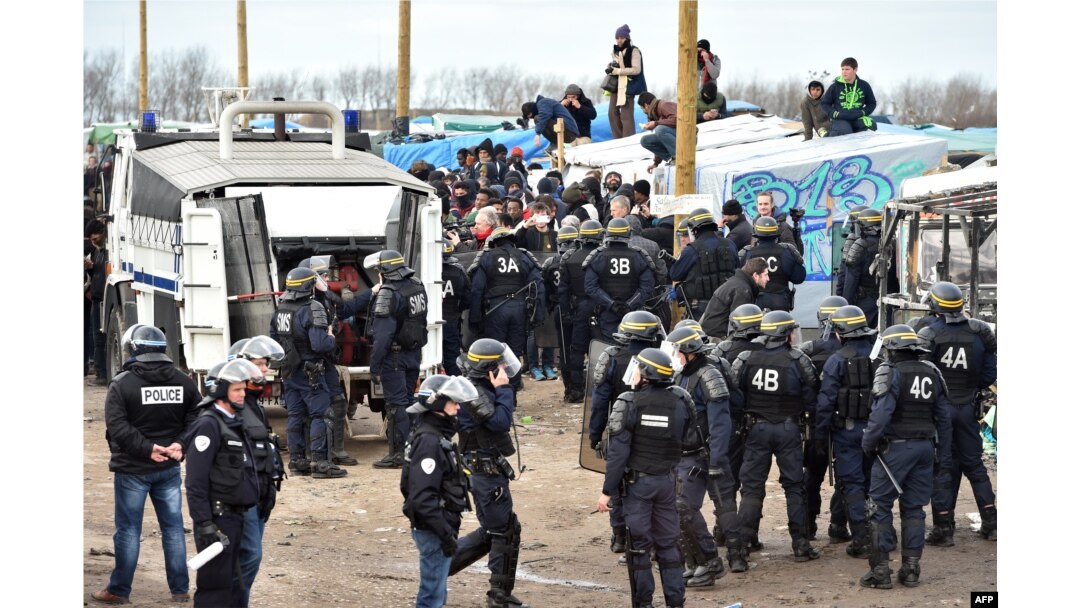 Anti-riot policemen face migrants during the dismantling of half of the "Jungle" migrant camp in the French northern port city of Calais, Feb. 29, 2016.