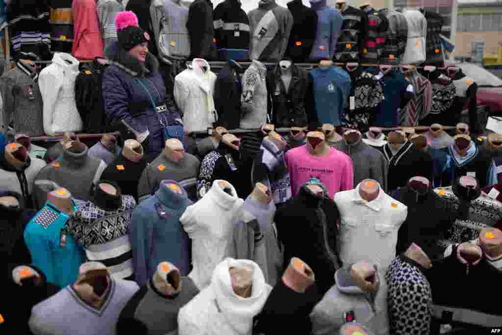 A Ukrainian seller stands amongst clothes in the Eastern Ukrainian city of Donetsk.