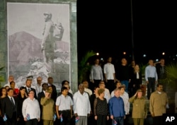 Cuba's President Raul Castro, second from right, salutes during a rally honoring his brother Fidel Castro at Antonio Maceo plaza in Santiago, Dec. 3, 2016.