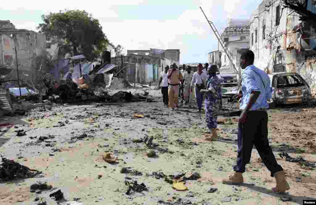 Somali police view the scene of a deadly blast in Mogadishu, April 14, 2013. 