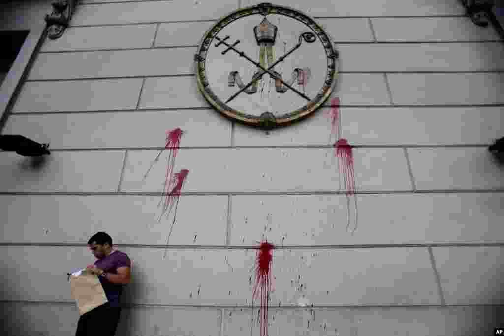 A man stands outside the Cathedral, which previously had been defaced during a protest against gender violence, in Buenos Aires, Argentina.