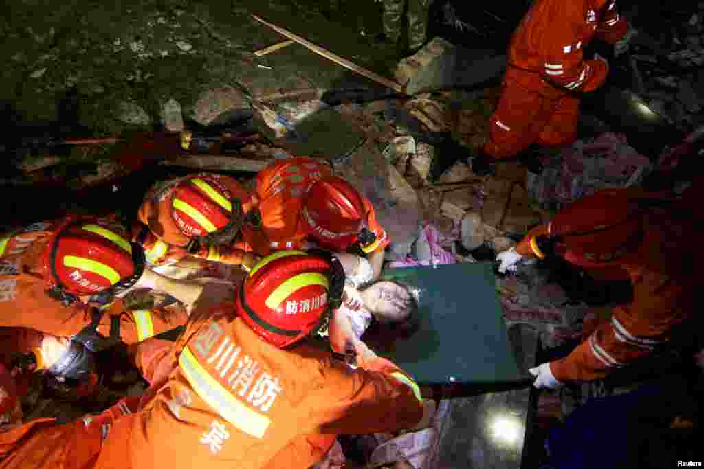 Rescue workers place a woman on a stretcher as they search for survivors in the wreckage after earthquakes hit Changning county in Yibin, Sichuan province, China.