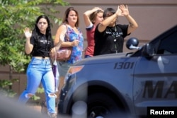 People leaving the shopping area of a mass shooting at a Walmart in El Paso, Texas.