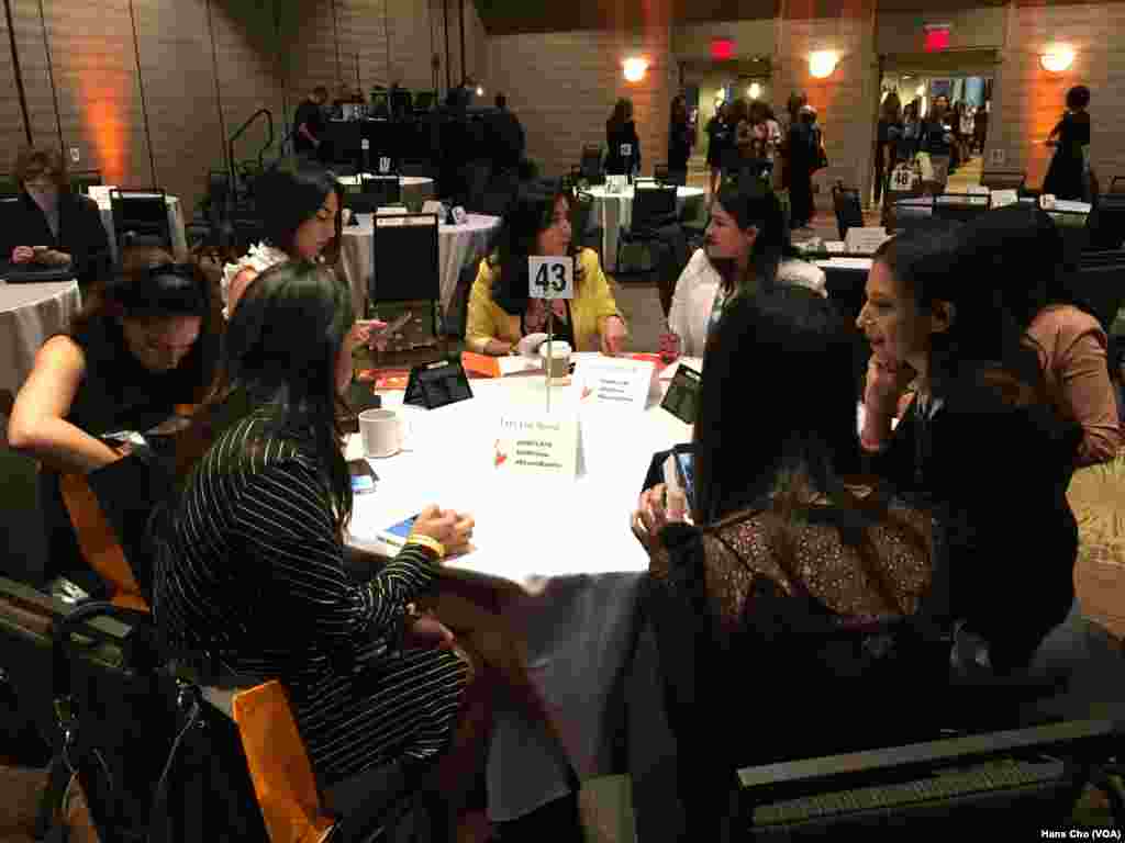 گروهی از زنان جوان ایرانی آمریکایی در کنفرانس با هم گفتگو می کنند.