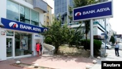Khách hàng sử dụng máy ATM tại một chi nhánh của Ngân hàng Asya tại Ankara, Thổ Nhĩ Kỳ.