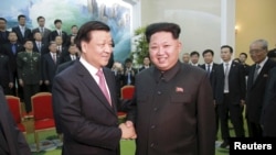 FILE - North Korean leader Kim Jong Un receives a delegation of the Communist Party of China led by Liu Yunshan. Analysts say competition between Beijing and Washington for power and influence in Asia is at the heart of China’s recent outreach to North Ko
