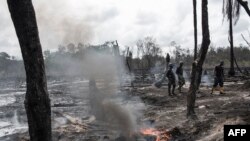 Des membres de la Force opérationnelle interarmées, Opération Delta Safe (OPDS), traversent une raffinerie de pétrole illégale récemment détruite dans la région du delta du Niger près de la ville de Warri, Nigeria, 19 avril 2017.