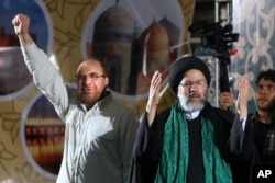 Iranian presidential candidate cleric Ebrahim Raisi, right, waves to his supporters while he is accompanied by Tehran Mayor Mohammad Bagher Qalibaf upon arrival at a campaign rally for the May 19 election at Imam Khomeini grand mosque in Tehran.