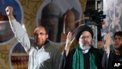 FILE - Iranian presidential candidate cleric Ebrahim Raisi, right, waves to his supporters while he is accompanied by Tehran Mayor Mohammad Bagher Qalibaf. 