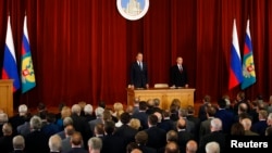 Russian President Vladimir Putin (R, back), Foreign Minister Sergei Lavrov (L, back), Russian ambassadors, envoys and diplomats listen to the national anthem during a meeting in Moscow, July 1, 2014.