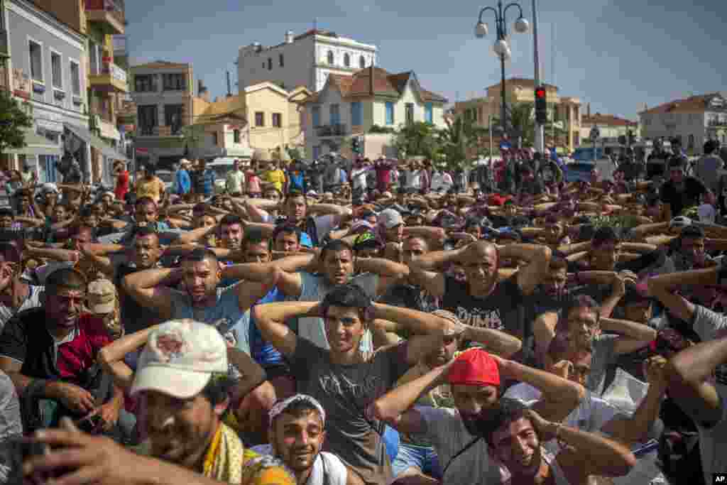 Refugees and migrants take part in a protest to demand faster processing by local authorities of their registration and the issuing of travel documents, at the port of Mytilene, on the northeastern Greek island of Lesbos, Sept. 7, 2015.