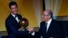 Pemain depan Real Madrid dan Portugal Cristiano Ronaldo menerima piala FIFA Ballon d'Or dari Presiden FIFA Joseph Blatter dalam upacara di Zurich (12/1). (Reuters/Ruben Sprich)