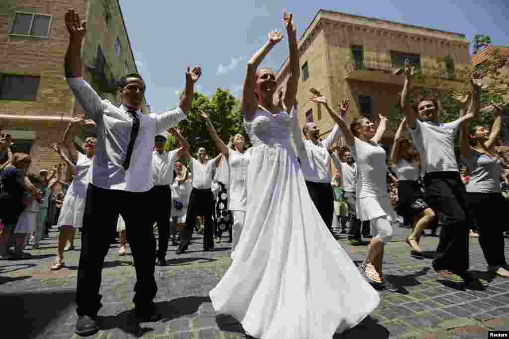 Israelis dressed as brides and grooms dance during a flash mob event promoting gender equality, in Jerusalem.