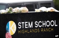 A light snow covers bouquets of flowers placed on the sign for STEM School Highlands Ranch following Tuesday's shooting, in Highlands Ranch, Colorado, May 9, 2019.