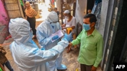 Staf medis mengenakan alat Pelindung Diri (APD), melakukan pemeriksaan medis dari pintu ke pintu di dalam daerah kumuh Dharavi untuk melawan penyebaran virus Covid-19, di Mumbai, 24 Juni 2020. 