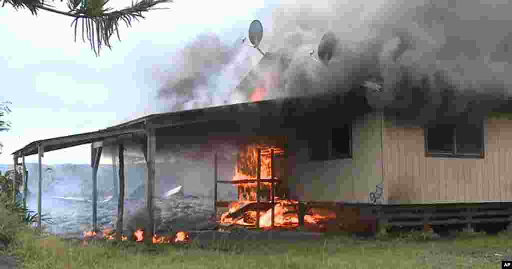 Sur&nbsp; cette image prise par le comté d&#39;Hawaii, la coulée de lave du volcan Kilauea brule une structure résidentielle le 11 novembre 2014,à Pahoa, Hawaii. &nbsp;