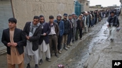 Afghan men line up for registration process before they cast their votes at a polling station in Kabul, Afghanistan, Saturday, April 5, 2014