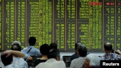 Investors look at stock information on an electronic board at a brokerage house in Hangzhou, Zhejiang province, Aug. 25, 2015. 