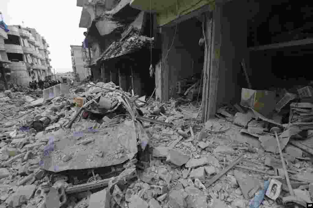 People inspect a damaged area after airstrikes on the town of Ariha, in Idlib province, Syria.