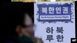 A North Korean defector calls for reform in the North during a rally in Seoul, South Korea, seeking for improvements in the human rights situation in North Korea, Tuesday, Nov. 18, 2014. (AP Photo/Lee Jin-man)