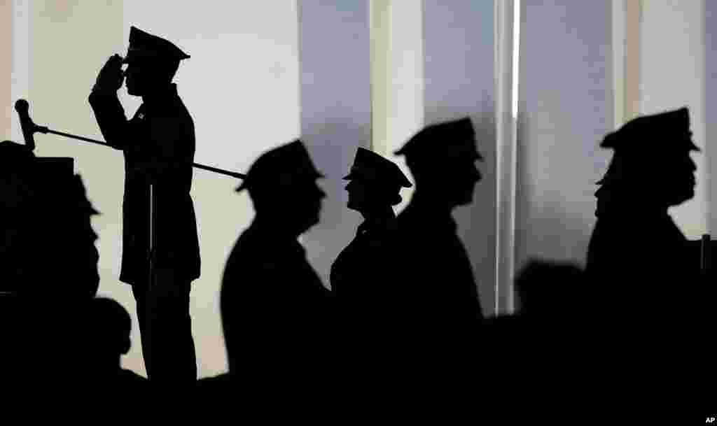 Jean Charlot, top, an officer with the Port Authority of New York and New Jersey Police Department, salutes as he is introduced on stage during a ceremony promoting him to his new rank as sergeant, at St. Peter&#39;s University in Jersey City, New Jersey.