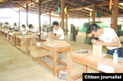 ພວກພະນັກງານ ແກະສະຫລັກໄມ້ ຢູ່ທີ່ໂຮງງານປຸງແຕ່ງໄມ້ແຫ່ງນຶ່ງໃນລາວ