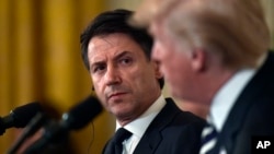 Italian Prime Minister Giuseppe Conte, left, listens as President Donald Trump, right, speaks during a news conference in the East Room of the White House in Washington, July 30, 2018. 