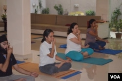 Sudiksha Sahni (third from left) does breathing exercises at an early morning yoga class in the business hub of Gurgaon. (Anjana Pasricha/VOA)