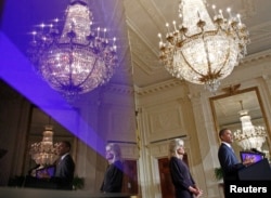 U.S. President Barack Obama and Dr. Jill Biden, wife of U.S. Vice President Joe Biden, are reflected in a monitor at the Community College Summit in the East Room at the White House in Washington, October 5, 2010. REUTERS/Jim Young