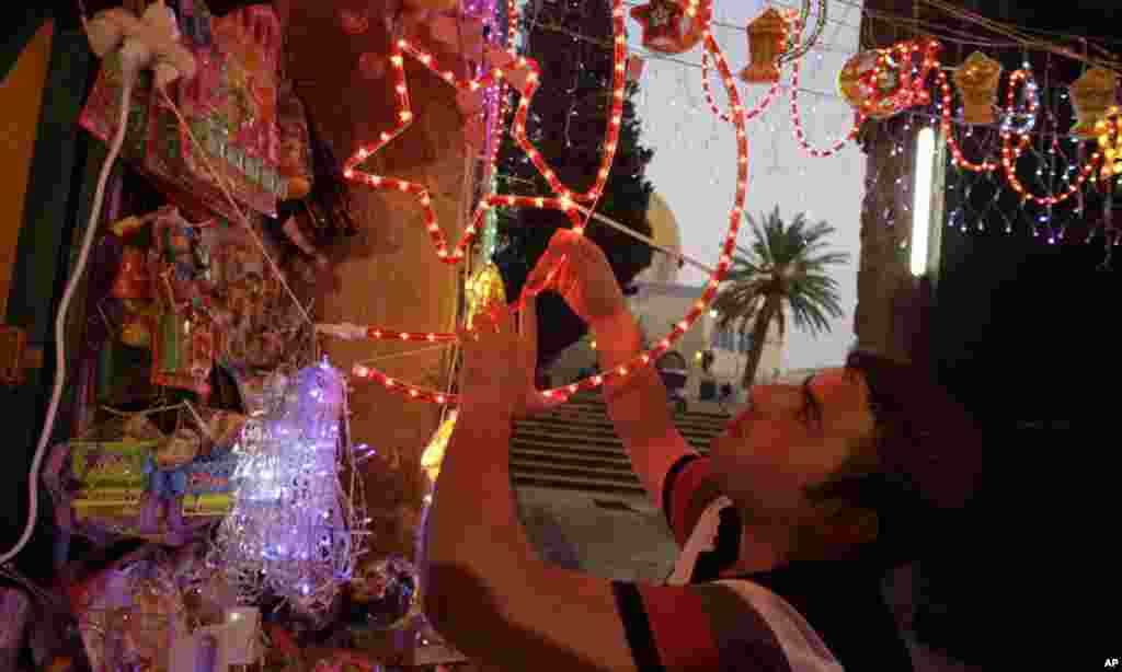 A Palestinian vendor hangs decorations for the upcoming holy month of Ramadan at a market in Jerusalem's Old City July 31, 2011. Muslims around the world abstain from eating, drinking and conducting sexual relations from sunrise to sunset during Ramadan, 
