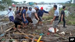 Bamwe mu banyagihugu bagerageza kwegeranya abahitanywe na tsunami 