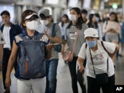 Passengers wearing masks as a precaution against the MERS virus make their way after they got off a train at a subway station in Seoul, South Korea, June 18, 2015.