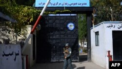 Seorang polisi Afghanistan berjaga di depan pintu gerbang penjara di Herat, 29 Oktober 2020. (Foto: HOSHANG HASHIMI / AFP)