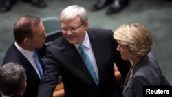 Australian Prime Minister Kevin Rudd (C) greets members of the Opposition including Opposition Leader Tony Abbott (L) and Deputy Leader Julie Bishop before Parliament starts at the Parliament House in Canberra, June 27, 2013. 