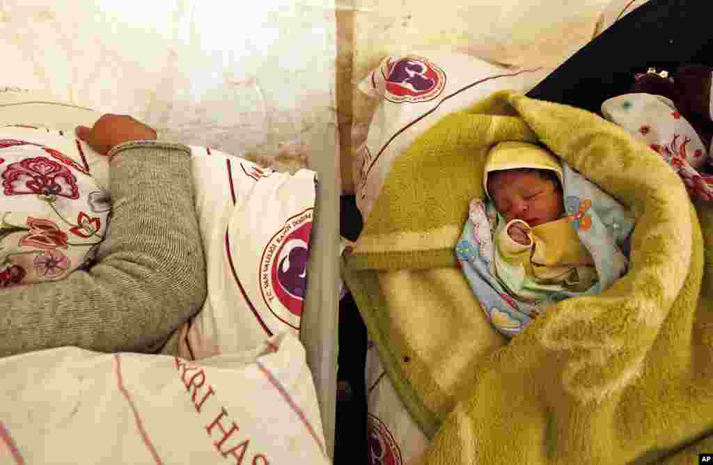 Today born baby Gurbet sleeps next to his mother Fezile Sonmez, 21, in a tent at an improvised maternity ward outside a canteen in Van, October 25, 2011. (Reuters)