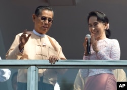Leader of Myanmar's National League for Democracy party, Aung San Suu Kyi, delivers a speech with party patron Tin Oo from a balcony of her party's headquarters in Yangon, Myanmar, Nov. 9, 2015.