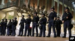 FILE - In this Feb. 1, 2017, photo, University of California, Berkeley police guard the building where Breitbart News editor Milo Yiannopoulos was to speak in Berkeley.