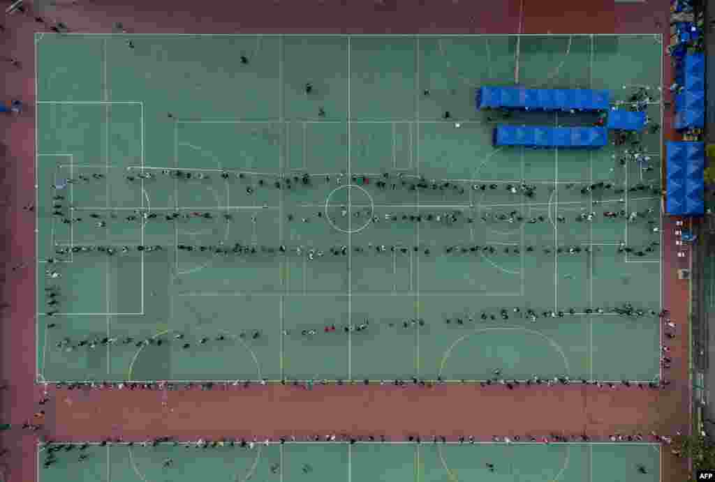 This image from above shows locals forming long lines at an outdoor mobile collection station for COVID-19 testing in Hong Kong.