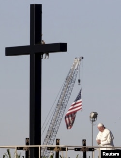 Pope Francis stands next to a wooden cross at the border between Mexico and the U.S. in Ciudad Juarez, Mexico, Feb. 17, 2016.