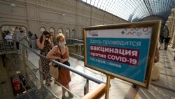 People stand in line to get a coronavirus vaccine at a center in the GUM, State Department store, in Red Square in Moscow, Russia, Tuesday, June 22, 2021. An ambitious plan of vaccinating 30 million Russians by mid-June against the coronavirus has fallen short by a third.