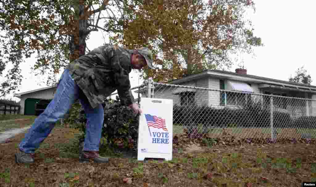 A voter adjusts a sign as he leaves the home of Vincent Smith in Varnville, South Carolina. The polling place for the U.S. presidential and local elections is located in the den of Smith's home.