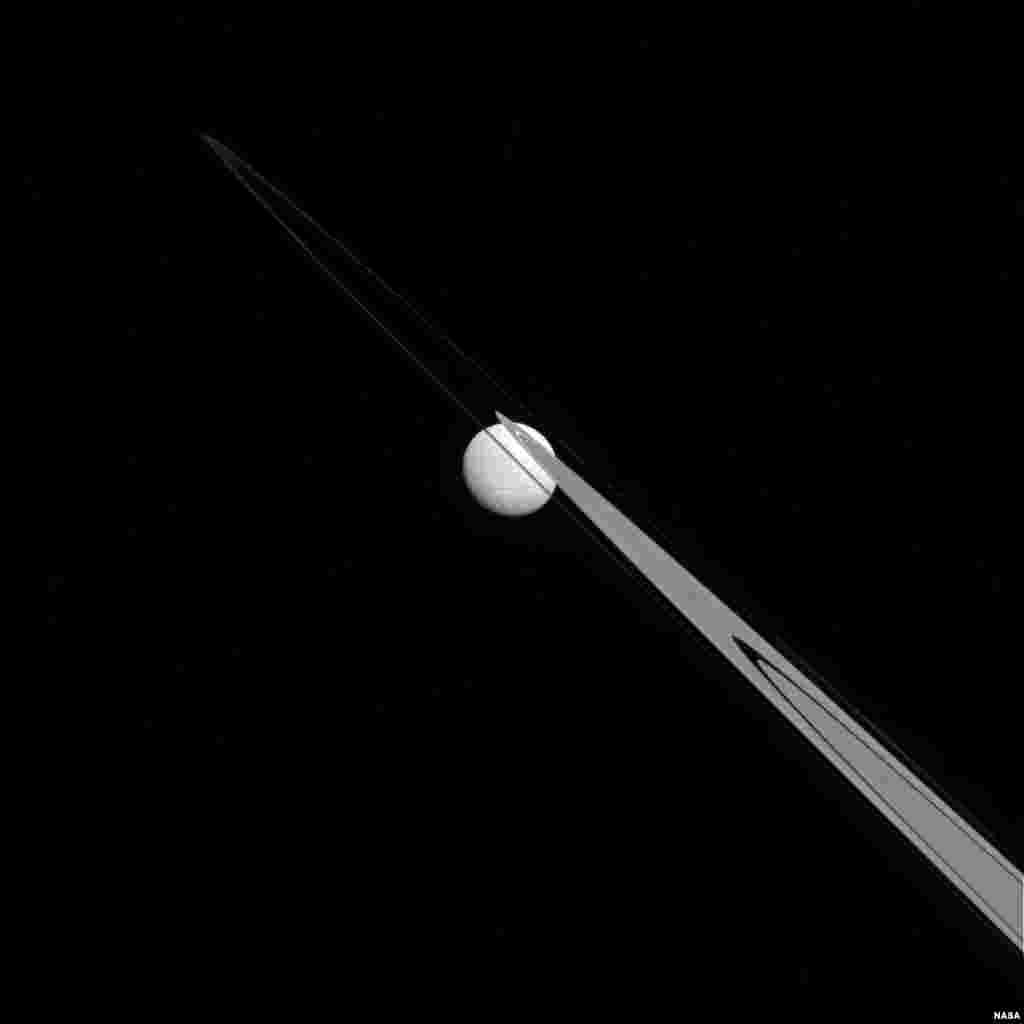 Like a drop of dew hanging on a leaf, Tethys appears to be stuck to the A and F rings from this perspective. Tethys (660 miles, or 1,062 kilometers across), like the ring particles, is composed primarily of ice. (Credit: NASA/JPL-Caltech/Space Science Institute)