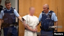 Brenton Tarrant, charged for murder in relation to the mosque attacks, is lead into the dock for his appearance in the Christchurch District Court, New Zealand, March 16, 2019. (Suspect's face blurred at source)