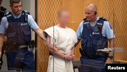 Brenton Tarrant, charged for murder in relation to the mosque attacks, is lead into the dock for his appearance in the Christchurch District Court, New Zealand, March 16, 2019. (Suspect's face blurred at source)