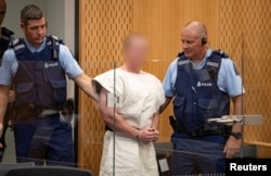 Brenton Tarrant, charged for murder in relation to the mosque attacks, is lead into the dock for his appearance in the Christchurch District Court, New Zealand, March 16, 2019