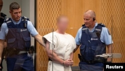 Brenton Tarrant, charged for murder in relation to the mosque attacks, is lead into the dock for his appearance in the Christchurch District Court, New Zealand, March 16, 2019. (Suspect's face blurred at source)