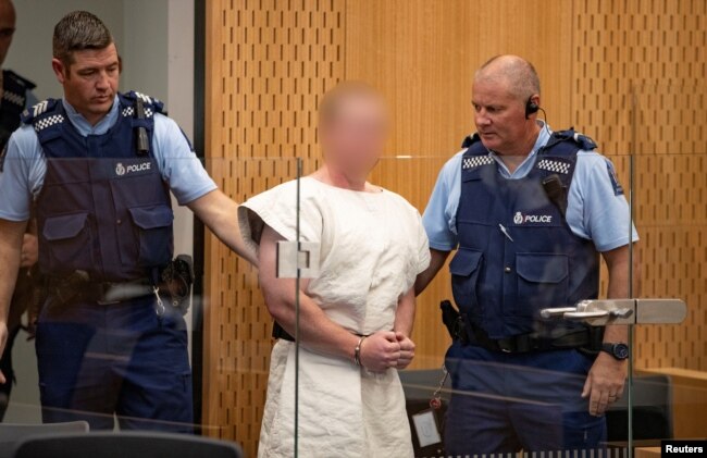 Brenton Tarrant, charged for murder in relation to the mosque attacks, is lead into the dock for his appearance in the Christchurch District Court, New Zealand, March 16, 2019. (Suspect's face blurred at source)