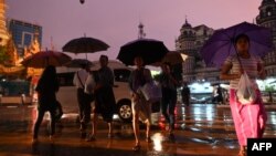 မိုးရွာနေချိန်အတွင်း ရန်ကုန်မြို့ပေါ်ရှိလမ်းသွားလမ်းလာတချို့ကိုတွေ့ရစဉ် (ဇူလိုင် ၁၈၊ ၂၀၁၉)